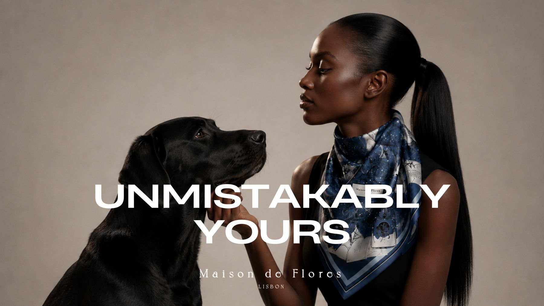 A woman in a navy scarf facing a black Labrador, with the words Unmistakably Yours